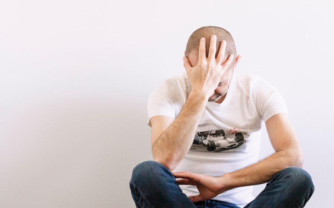 Man looking depressed with a hand in the head