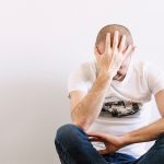 Man looking depressed with a hand in the head